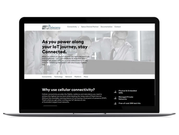 A laptop screen featuring the M2M Telecommunications &mdash; WordPress CMS Website by Digital Dividend, highlighting cellular connectivity services like Physical & Embedded SIMs.